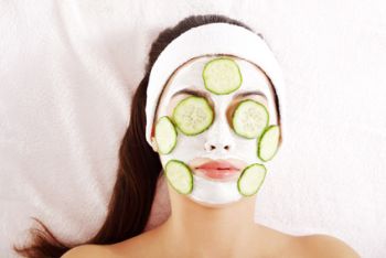 Young woman with cucumber slices on the face in a spa saloon
